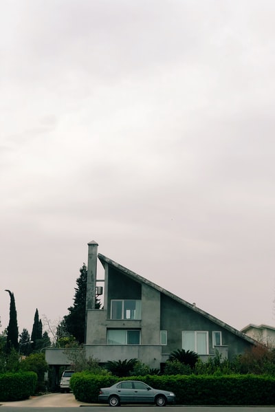 The gray car parked beside the house
